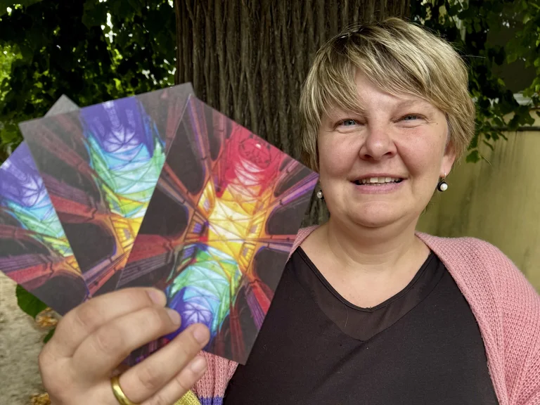 Eine Frau zeigt bunte Postkarten