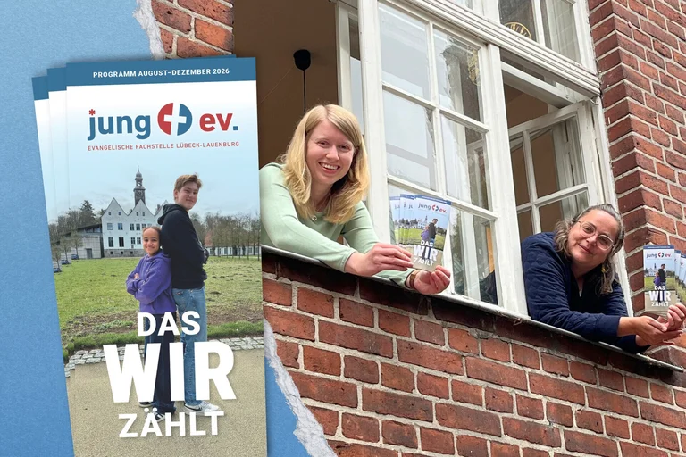 Zwei Frauen schauen aus einem Fenster und halten Flyer in den Händen.