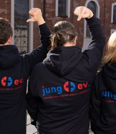 Team der Fachstelle in Rückansicht mit neuen Hoodies