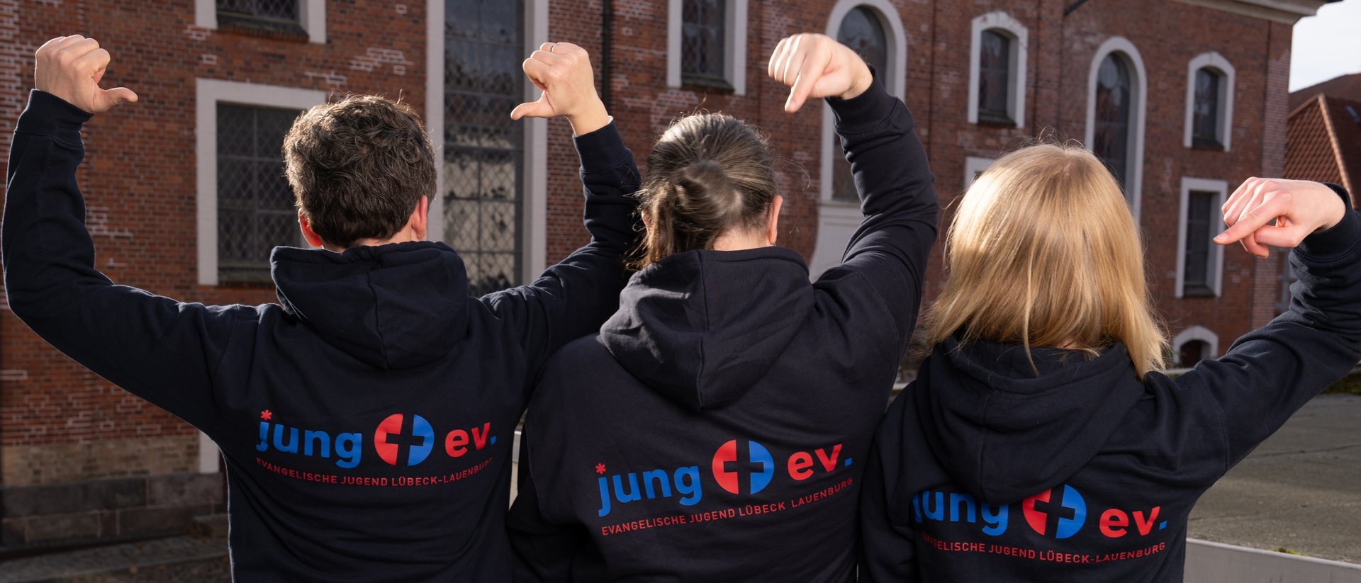 Team der Fachstelle in Rückansicht mit neuen Hoodies